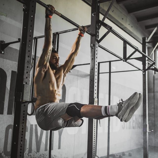 Athlete performs a hanging leg raise on a pull-up rig